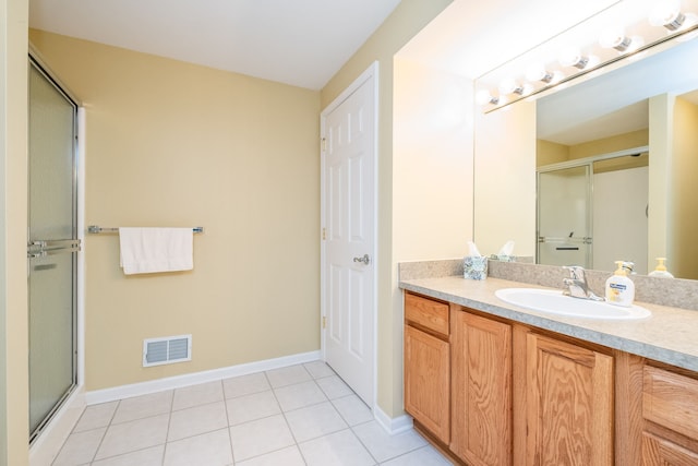 full bathroom featuring tile patterned flooring, vanity, baseboards, an enclosed shower, and visible vents