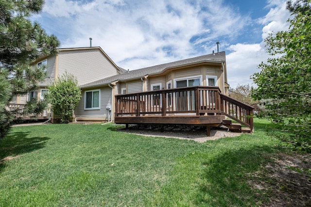 rear view of house featuring a wooden deck and a yard