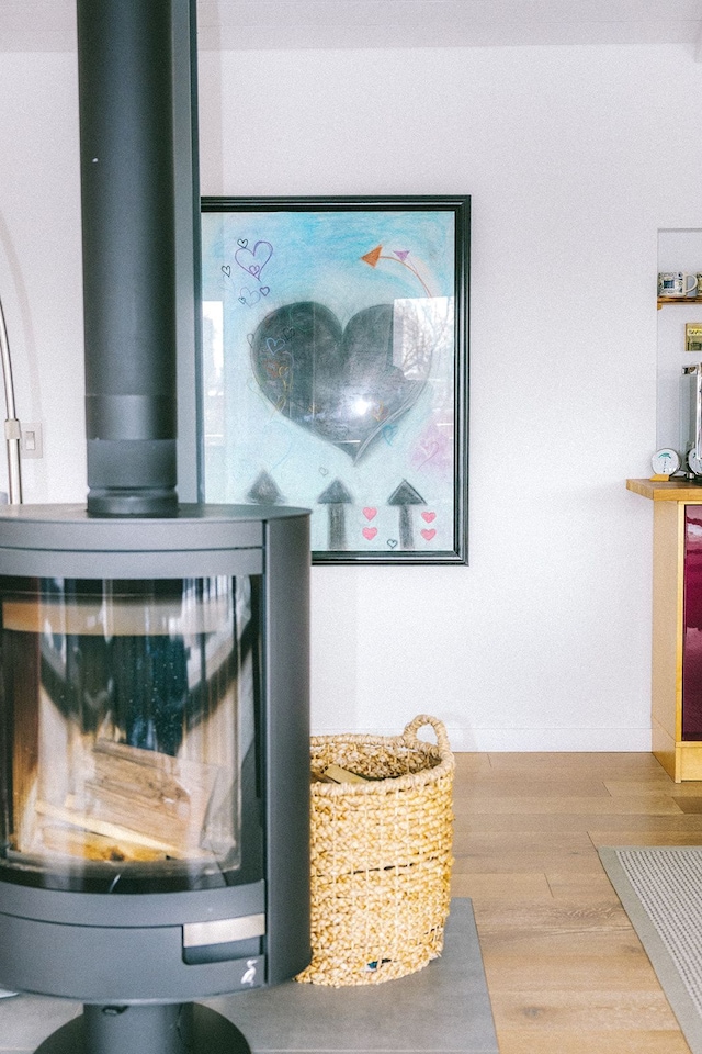 details featuring a wood stove and wood finished floors