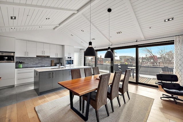 dining area with high vaulted ceiling, beam ceiling, wood ceiling, and light wood-style flooring