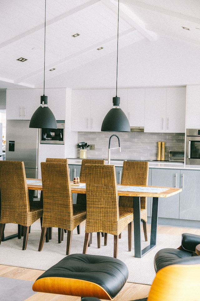 dining space with vaulted ceiling with beams