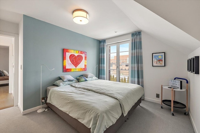 bedroom with baseboards, vaulted ceiling, and light carpet