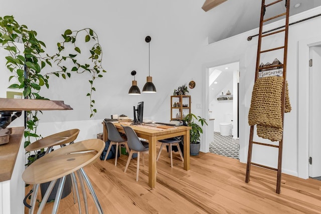 dining space with lofted ceiling and light wood finished floors