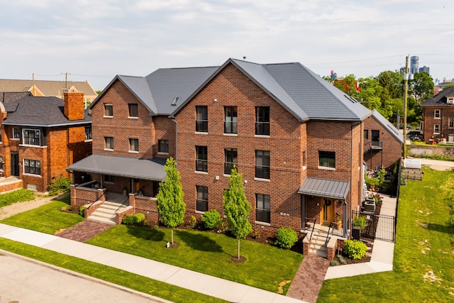 view of front of property featuring covered porch, a front lawn, and brick siding