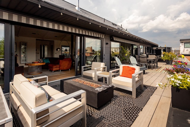 deck featuring an outdoor living space with a fire pit