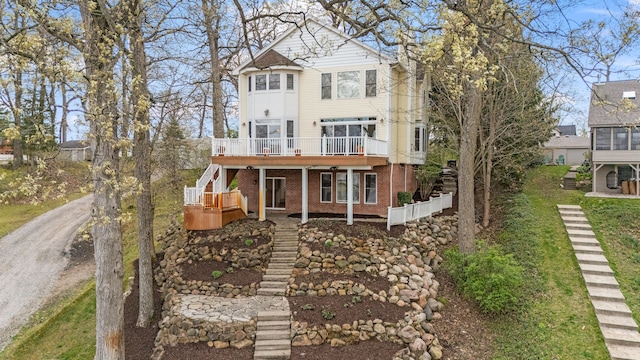5027 Grover Dr, Brighton, MI 48116 - rear view of property featuring brick siding, a wooden deck, and stairs