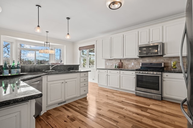 5027 Grover Dr, Brighton, MI 48116 - kitchen featuring a sink, stainless steel appliances, white cabinetry, and visible vents