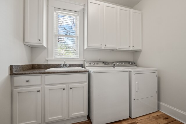 5027 Grover Dr, Brighton, MI 48116 - laundry room featuring washing machine and clothes dryer, light wood-style floors, cabinet space, and a sink
