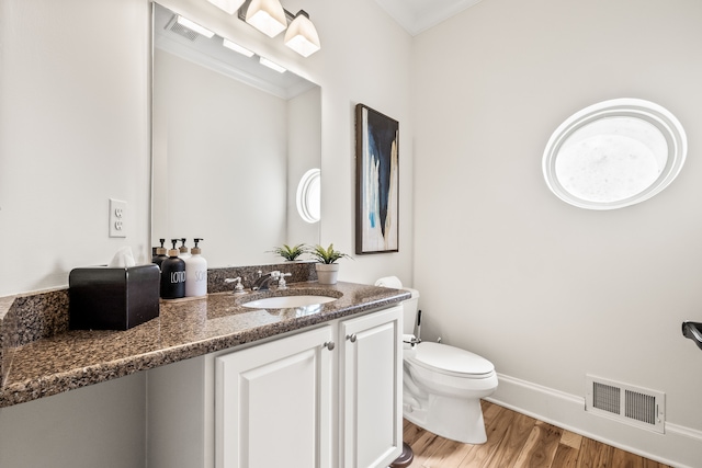 5027 Grover Dr, Brighton, MI 48116 - half bathroom with toilet, baseboards, visible vents, vanity, and wood finished floors