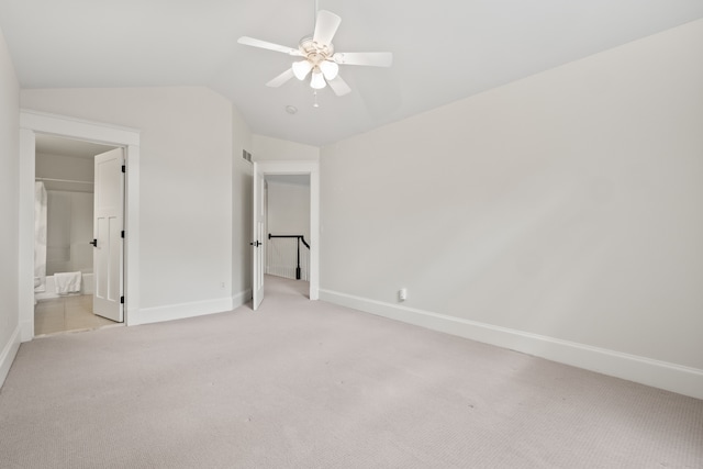 5027 Grover Dr, Brighton, MI 48116 - unfurnished bedroom featuring lofted ceiling, baseboards, ensuite bath, and light colored carpet