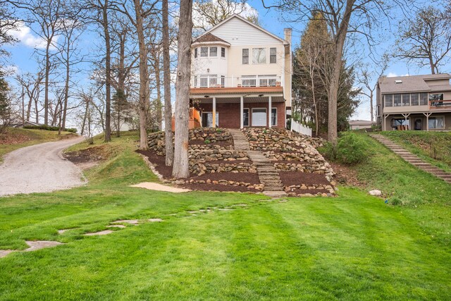 5027 Grover Dr, Brighton, MI 48116 - rear view of house featuring a lawn, a wooden deck, and a chimney