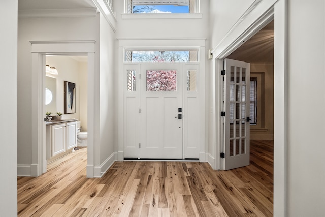 5027 Grover Dr, Brighton, MI 48116 - entrance foyer with crown molding, baseboards, and light wood-style floors