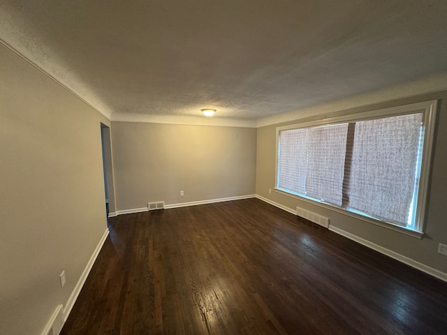 21260 Kipling St, Oak Park, MI 48237 - empty room with baseboards, dark wood finished floors, and visible vents