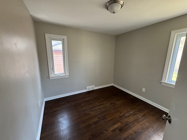 21260 Kipling St, Oak Park, MI 48237 - unfurnished room featuring baseboards, dark wood-style flooring, visible vents, and plenty of natural light