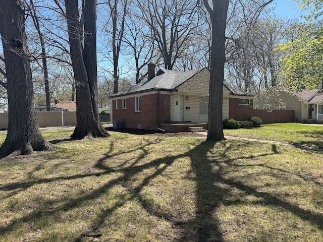 21260 Kipling St, Oak Park, MI 48237 - view of home's exterior with a chimney, a yard, brick siding, and fence
