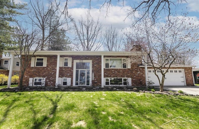 split foyer home featuring concrete driveway, brick siding, and a front lawn