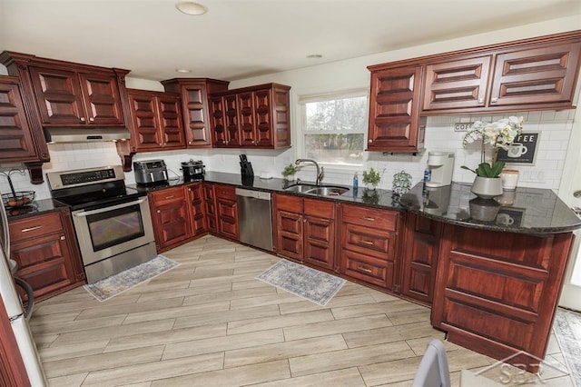 kitchen featuring decorative backsplash, dark brown cabinets, under cabinet range hood, a sink, and appliances with stainless steel finishes