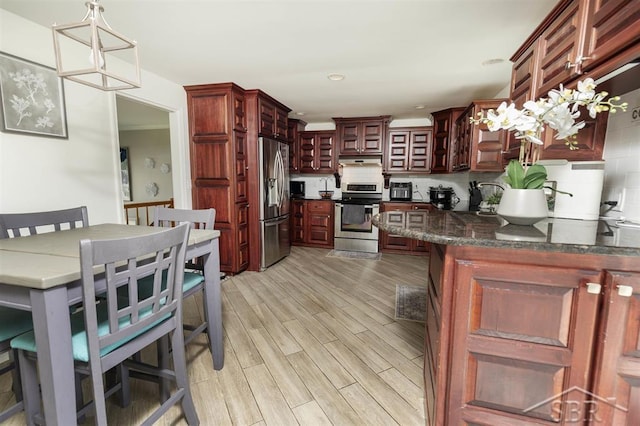 kitchen featuring decorative backsplash, decorative light fixtures, stainless steel appliances, recessed lighting, and light wood-style flooring