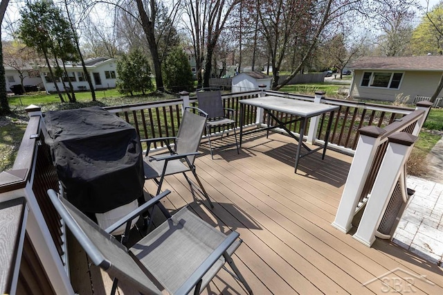 wooden deck featuring an outdoor structure and a shed