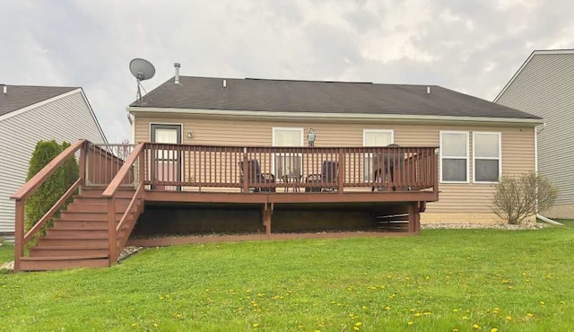 rear view of house with a wooden deck and a yard
