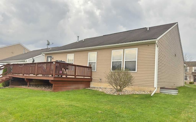 rear view of house featuring a lawn and a wooden deck