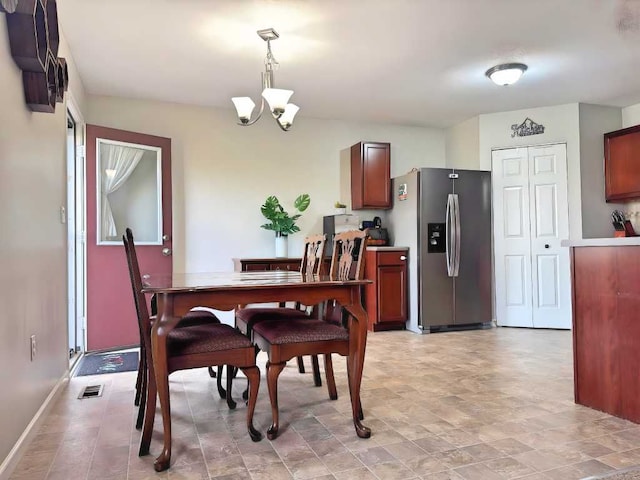 dining room with baseboards, a chandelier, and visible vents