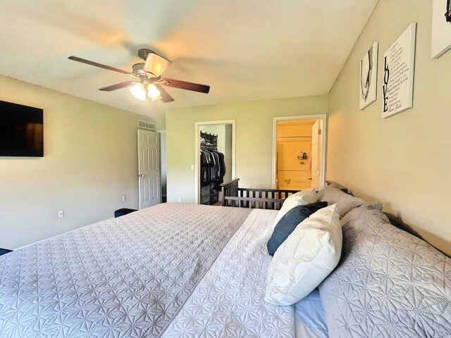bedroom featuring ceiling fan and a walk in closet