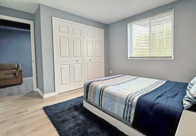 bedroom with a closet, baseboards, and wood finished floors