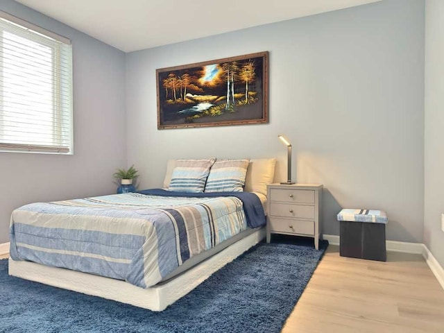 bedroom with baseboards and wood finished floors