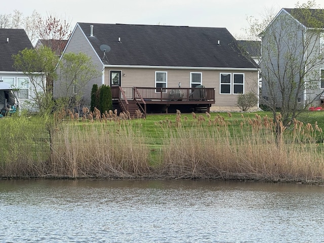 rear view of house with a deck with water view