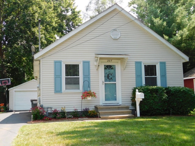 bungalow-style home featuring a detached garage, an outdoor structure, entry steps, and a front lawn