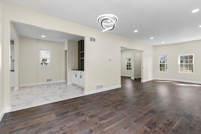 unfurnished living room featuring visible vents, recessed lighting, and baseboards