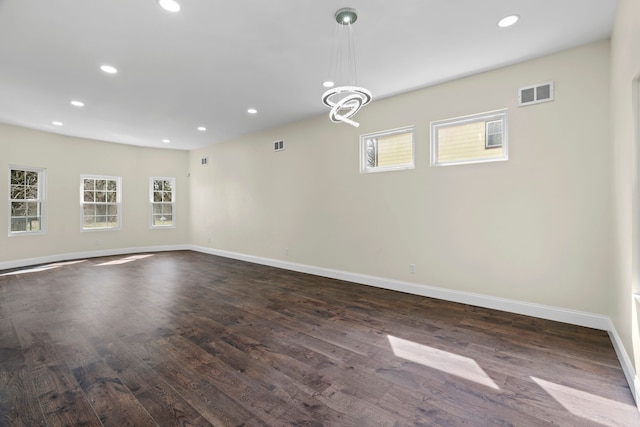 spare room featuring dark wood-style flooring, recessed lighting, and visible vents