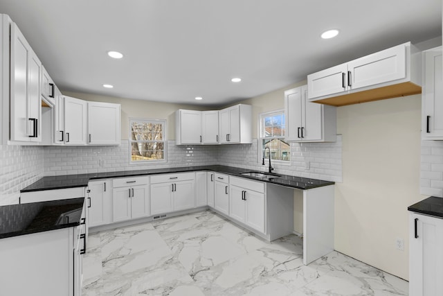 kitchen with recessed lighting, a sink, and marble finish floor