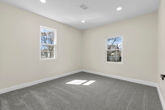 spare room featuring a healthy amount of sunlight, carpet floors, recessed lighting, and visible vents