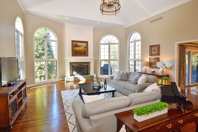 living room featuring a healthy amount of sunlight, high vaulted ceiling, and visible vents