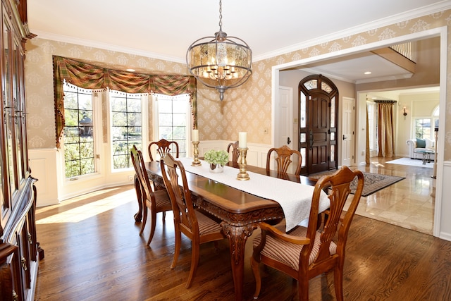 dining area with an inviting chandelier, plenty of natural light, wainscoting, and wallpapered walls