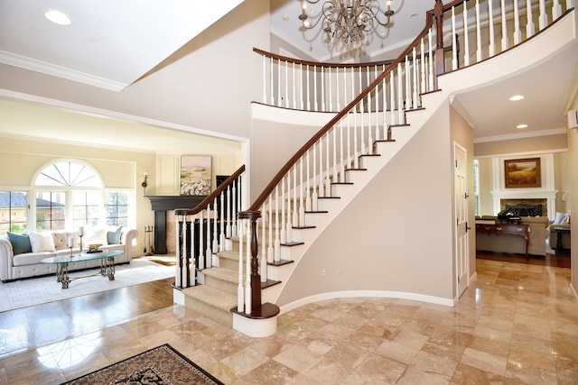 stairs featuring a high ceiling, ornamental molding, and a fireplace