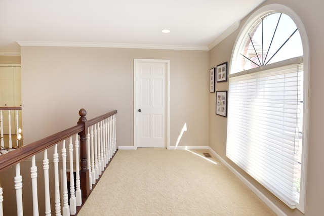 corridor featuring baseboards, ornamental molding, carpet floors, and visible vents