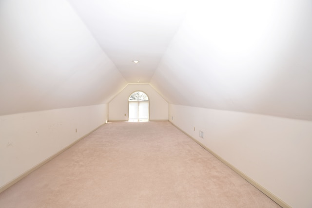 bonus room featuring baseboards, light colored carpet, and lofted ceiling