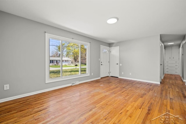 interior space with baseboards, visible vents, and wood finished floors