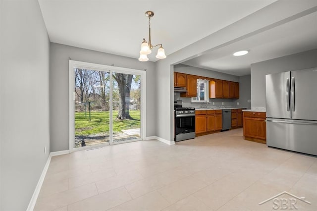 kitchen featuring appliances with stainless steel finishes, light countertops, a chandelier, brown cabinetry, and baseboards