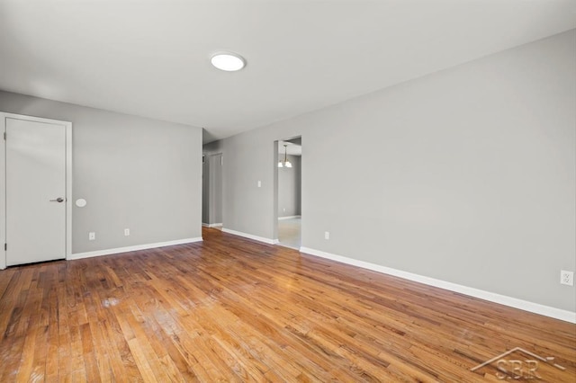 empty room with baseboards and hardwood / wood-style floors