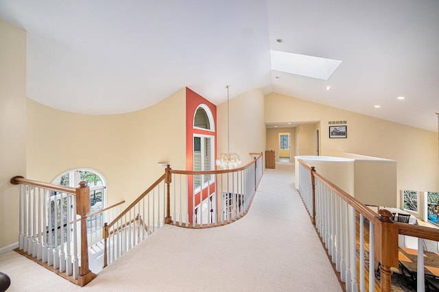 hallway featuring an upstairs landing, plenty of natural light, and carpet