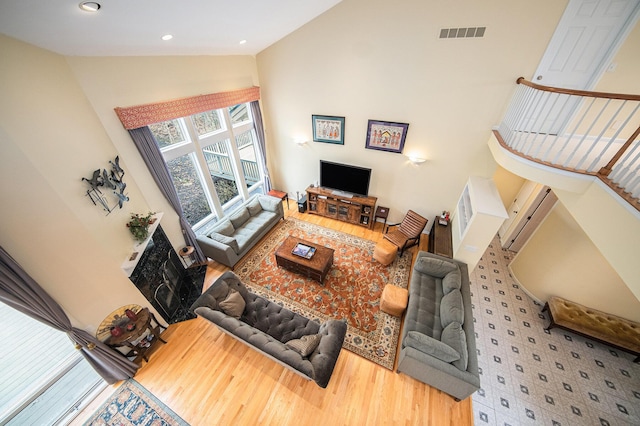 living area featuring visible vents, recessed lighting, wood finished floors, and vaulted ceiling
