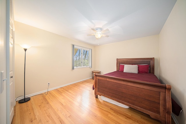 bedroom with ceiling fan, baseboards, and light wood-style floors