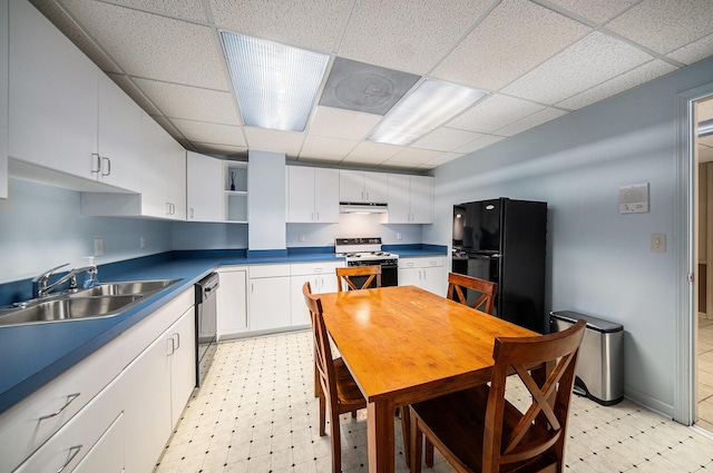 kitchen featuring a sink, light floors, black appliances, and a drop ceiling