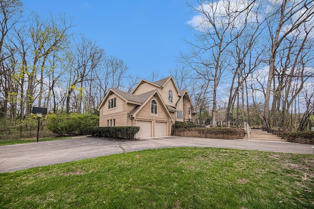 view of home's exterior featuring aphalt driveway, stairs, brick siding, an attached garage, and a yard
