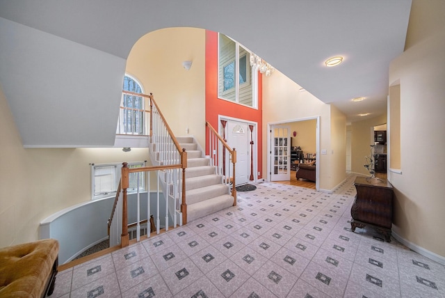 entrance foyer with baseboards, stairs, and a towering ceiling