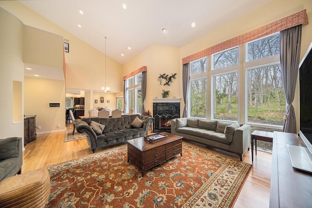living area featuring wood finished floors, a notable chandelier, and high vaulted ceiling